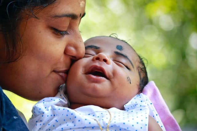 A mother kisses her baby